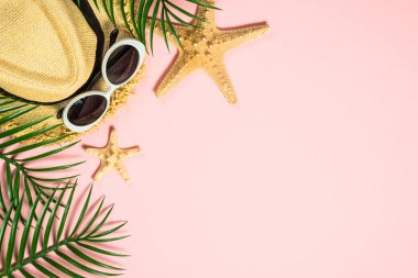 Pembe arka plan üst görünümünde yaz aksesuarları.