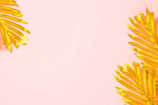 Hojas de palma dorada sobre fondo rosa . — Foto de Stock