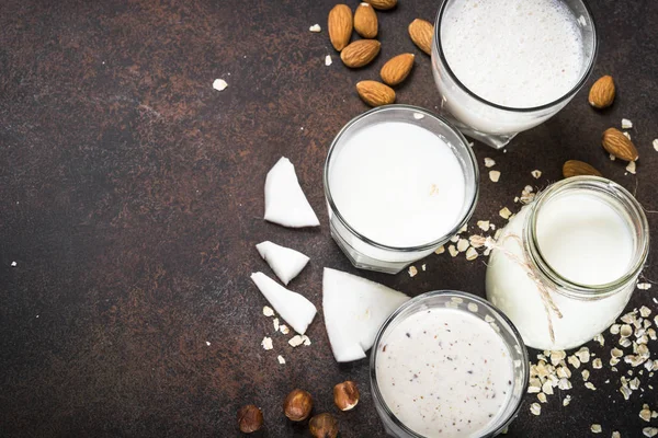 Vegansk alternativ melk, ikke melkeprodukter, på mørkerødt bord . – stockfoto