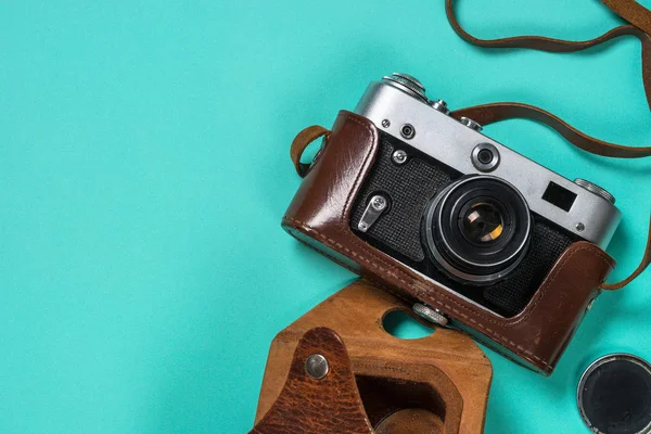Old film camera on turquoise background. — Stock Photo, Image