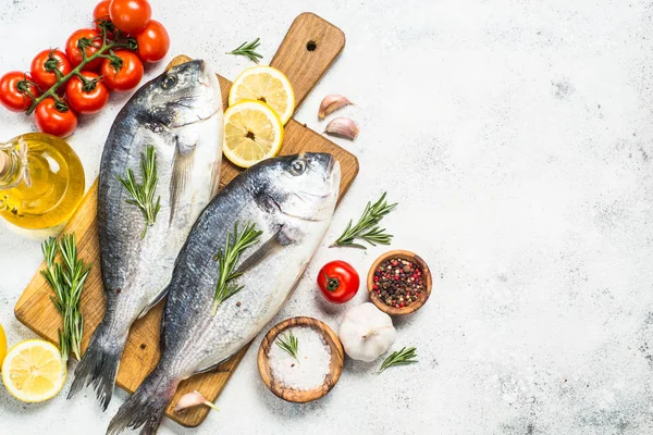 Pescado dorado crudo en la tabla de cortar en la mesa . —  Fotos de Stock