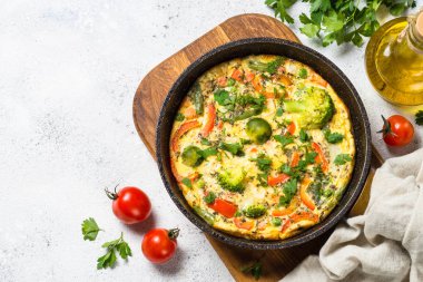 Beyaz taş masada sebze ile Frittata.