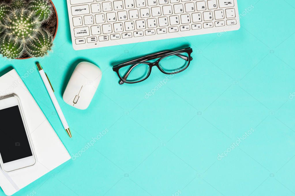 Office workplace with keyboard, notepad, succulent and pen