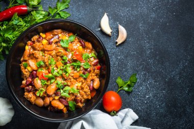 Chili con carne et ve sebze siyah tablo üstten görünüm