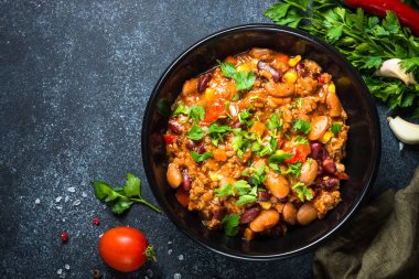 Chili con carne et ve sebze siyah tablo üstten görünüm