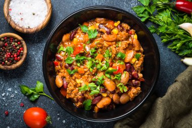Chili con carne et ve sebze siyah tablo üstten görünüm