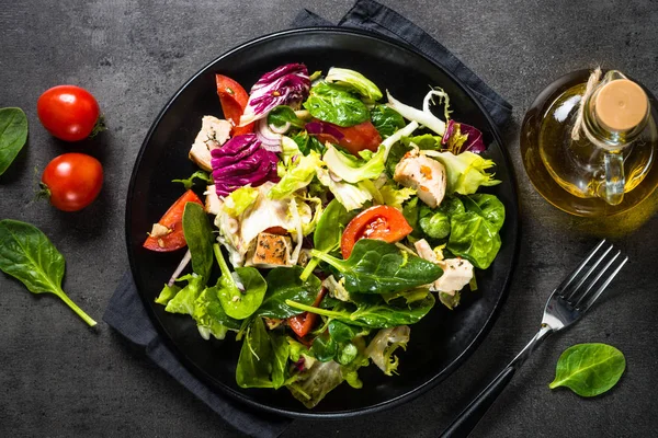 Зелений салат з куркою та овочами на чорному . — стокове фото