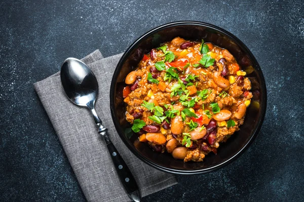 Chili con Carne aus Fleisch und Gemüse auf schwarzer Tischplatte — Stockfoto