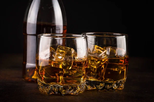 Whisky negli occhiali su sfondo scuro . — Foto Stock