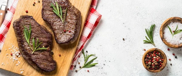 Bistecca di manzo alla griglia su tagliere di legno. — Foto Stock