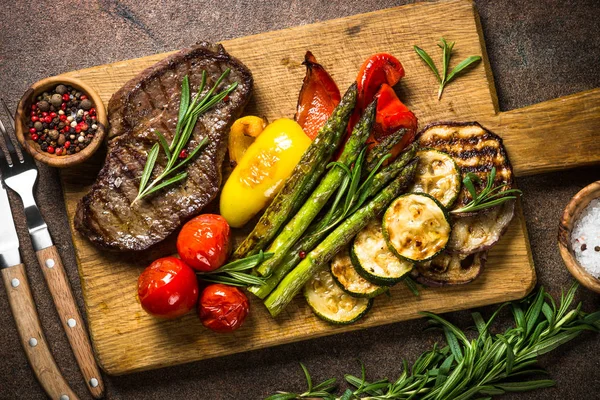 Bistecca di manzo alla griglia con verdure sul tagliere — Foto Stock