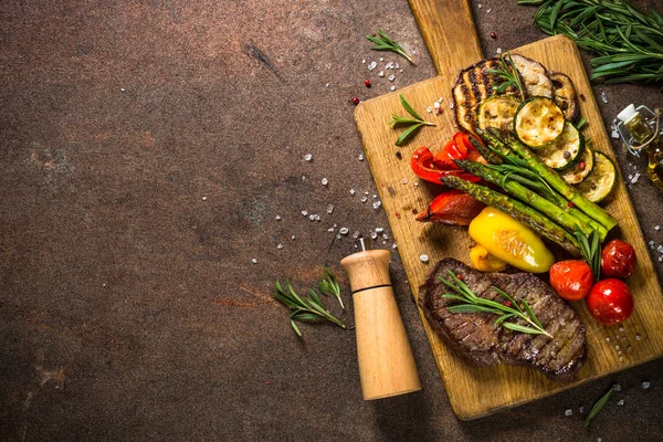 Nötstek grillad med grönsaker på skärbräda — Stockfoto