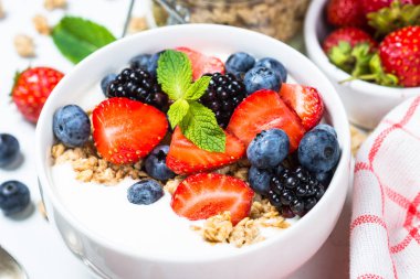 Beyaz masada taze çilek ile Yunan yoğurt granola.