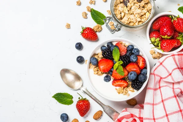 Granola yogurt Yunani dengan buah berry segar di atas meja putih . — Stok Foto
