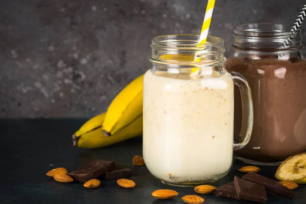 Milkshakes à la banane et au chocolat dans des pots . — Photo