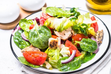 Beyaz üzerinde tavuk ve sebze ile yeşil salata.