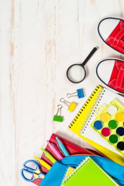 Beyaz arkaplanda kırtasiye malzemesi olan okul çantası.