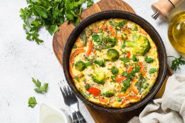 Beyaz taş masada sebze ile Frittata.