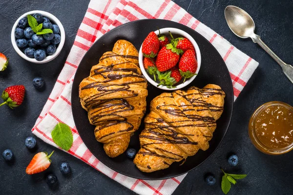 Croissant con bacche fresche e tazza di caffè su nero. — Foto Stock