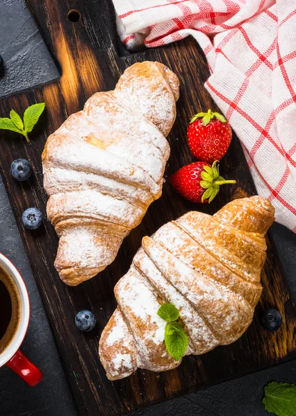 Croissant con bacche fresche e tazza di caffè su nero. — Foto Stock