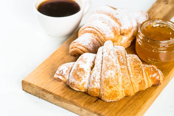 Croissant com geléia e café em branco . — Fotografia de Stock