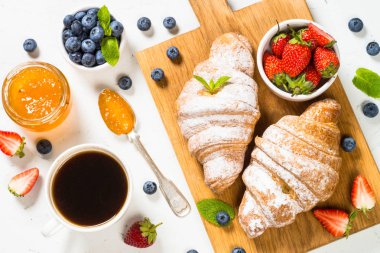 Taze böğürtlenli kruvasan ve bir fincan kahve.