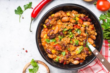 Chili con carne et ve sebze taş masa üstü görünümü.