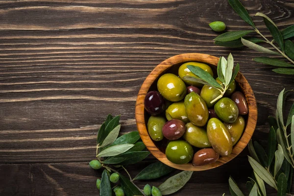 Ahşap masada siyah ve yeşil zeytin. — Stok fotoğraf