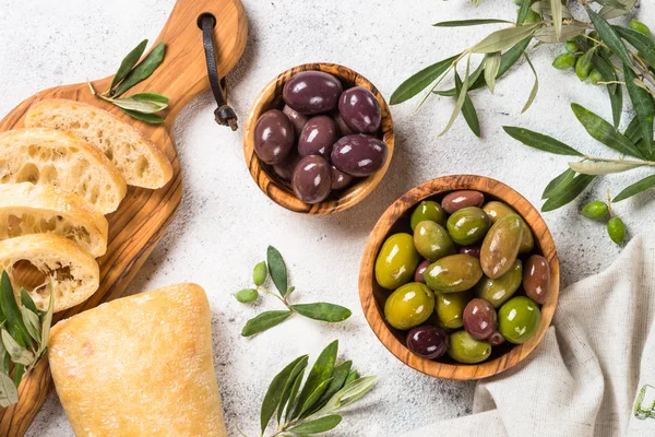 Olives, ciabatta and olive oil on white background. — Stock Photo, Image