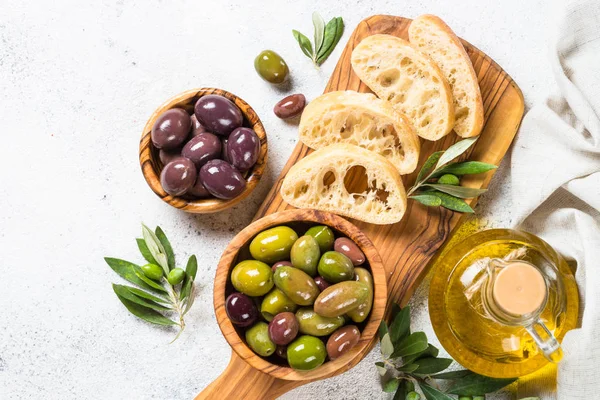 Aceitunas, ciabatta y aceite de oliva sobre fondo blanco. —  Fotos de Stock