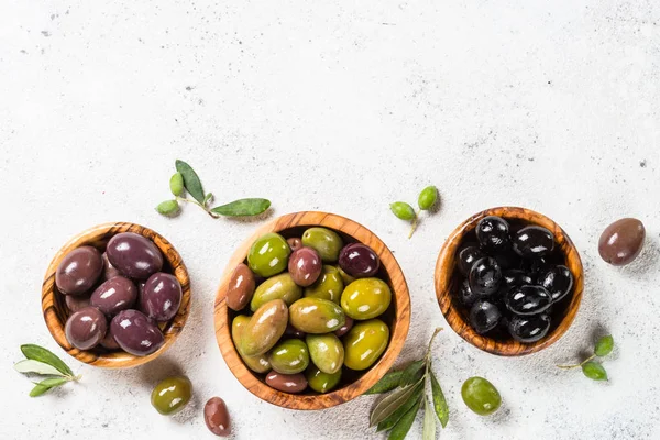 Svart och gröna oliver på vit bakgrund. — Stockfoto