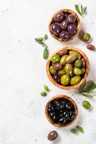Black and green olives on white background.