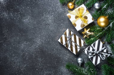 Noel arka plan - Altın ve gümüş süslemeleri ve siyah taş arka plan üzerinde mevcut kutu.