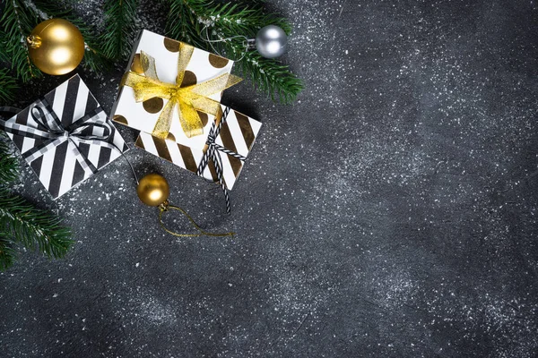 クリスマスの背景 - 黒い石の背景に金と銀の装飾とプレゼントボックス. — ストック写真