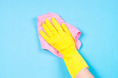 El sarı eldivenler ve mavi arka plan temizleme mikrofiber bez.