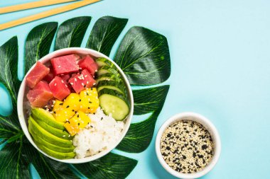 Pilav, avokado, mango ve mavi üzerine salatalık..