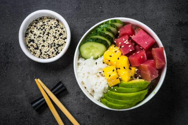 Tuna poke bowl on black background top view.