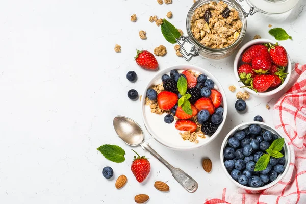 Греческий йогурт с ягодами на белом столе . — стоковое фото