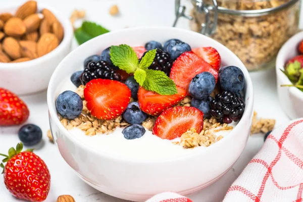 Granola de iogurte grego com bagas frescas na mesa branca . — Fotografia de Stock