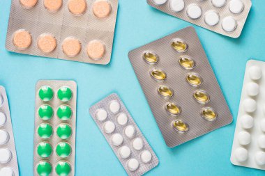 Tabletler ve vitamin mavi bir arka plan üzerinde.