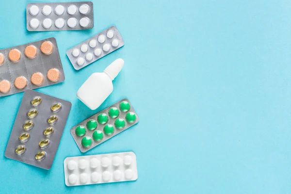 Tabletták és gyógyszerek, kék háttérrel. — Stock Fotó