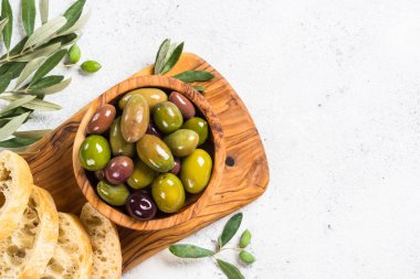Beyaz arka planda zeytin, ciabatta ve zeytinyağı.