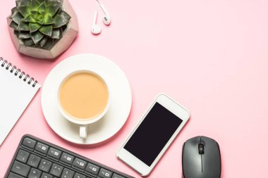 Not defteri, kahve fincanı ve pembe bir arka plan üzerinde klavye ile Ofis İşyeri.