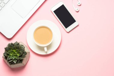 Not defteri, kahve fincanı ve pembe bir arka plan üzerinde klavye ile Ofis İşyeri.
