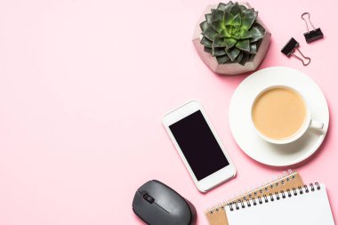 Not defteri, kahve fincanı ve pembe bir arka plan üzerinde klavye ile Ofis İşyeri.