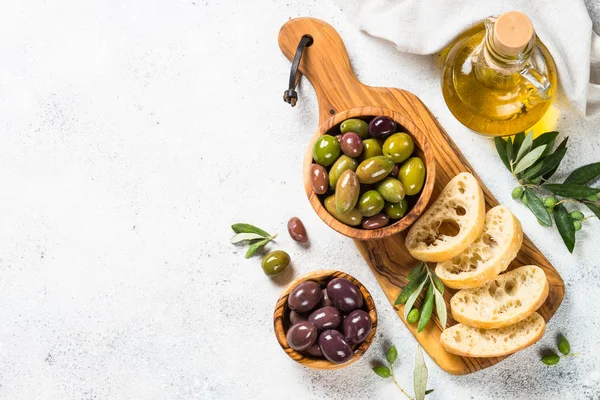 Aceitunas, ciabatta y aceite de oliva sobre fondo blanco. — Foto de Stock