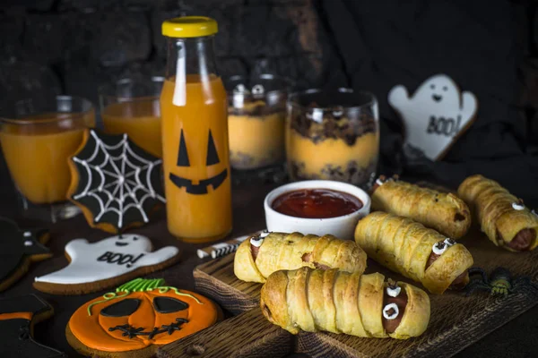 Halloween food assortment - sasage mummies, pumpkin dessert, gin