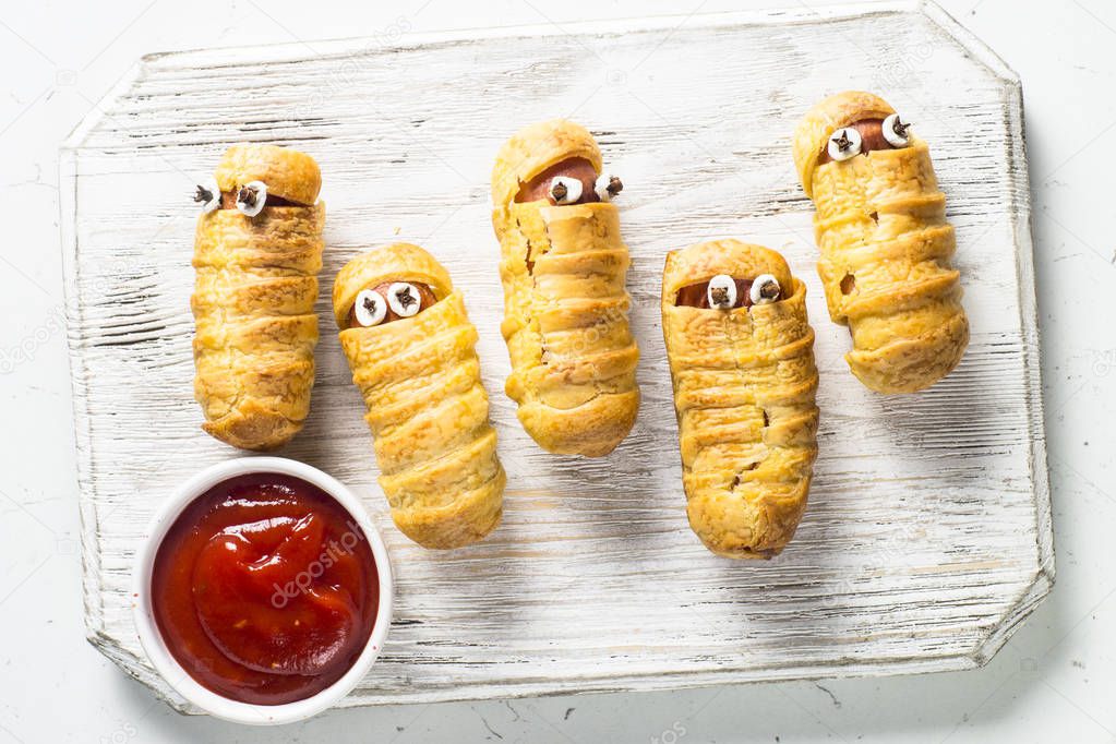 Halloween food. Scary sausage mummies in dough.