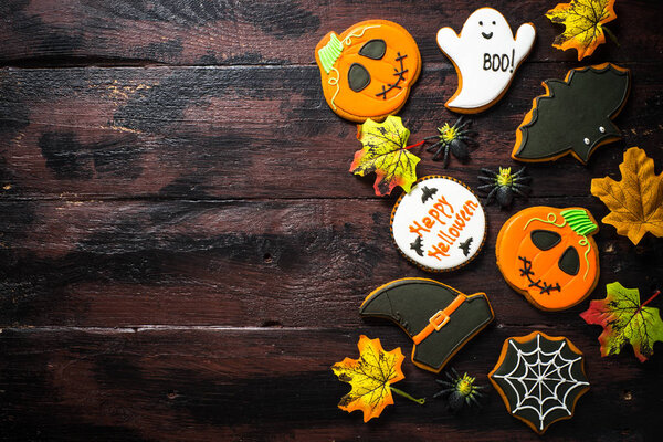 Halloween Gingerbread Cookies - pumpkin, ghosts, bat, on woden table.