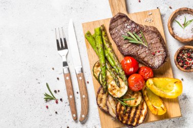 Beyaz taş masada sebze ile ızgara Sığır eti biftek.